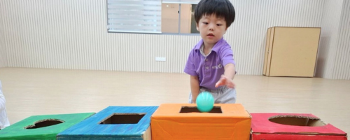 Boy putting ball in a box